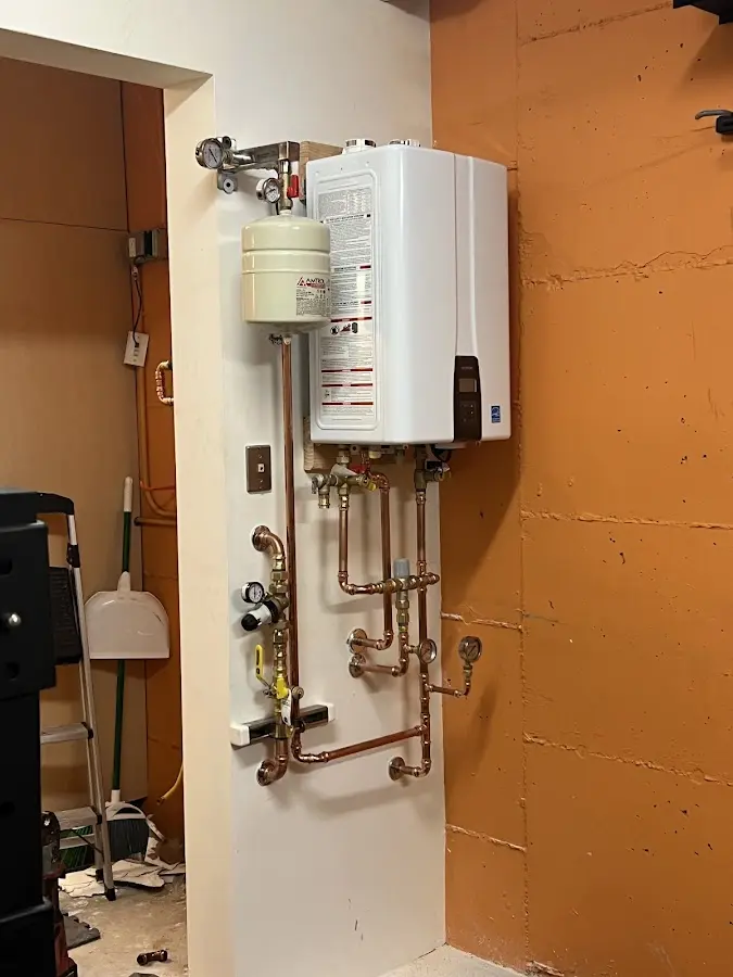 Plumbing technician inspecting water heater connections in Quantico Base